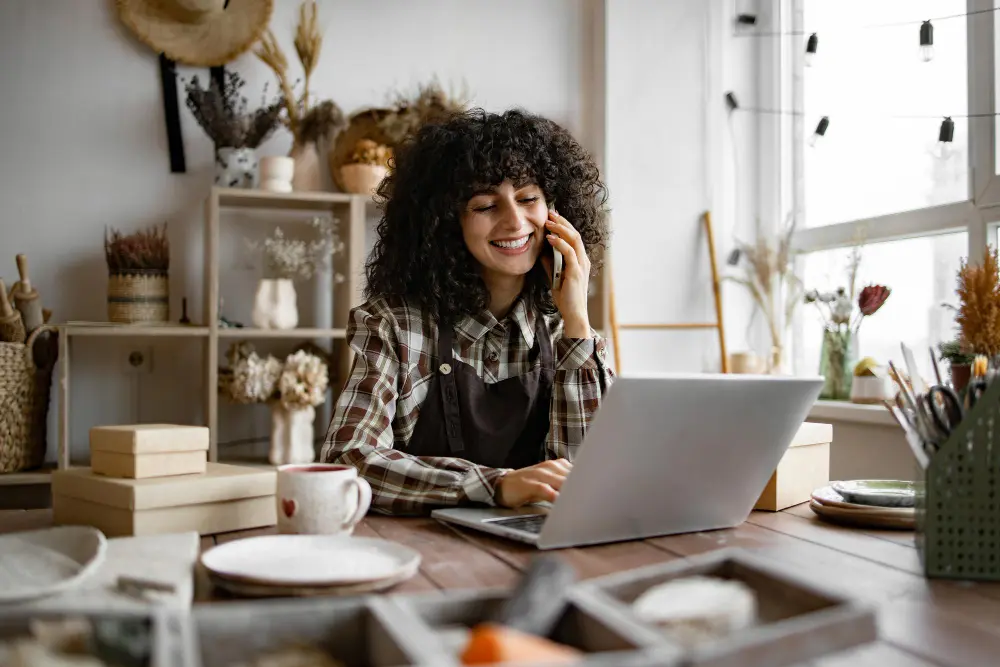 Mujer empresaria utilizando un CRM en su computadora portátil para gestionar clientes, optimizando la eficiencia operativa de su pequeña empresa.