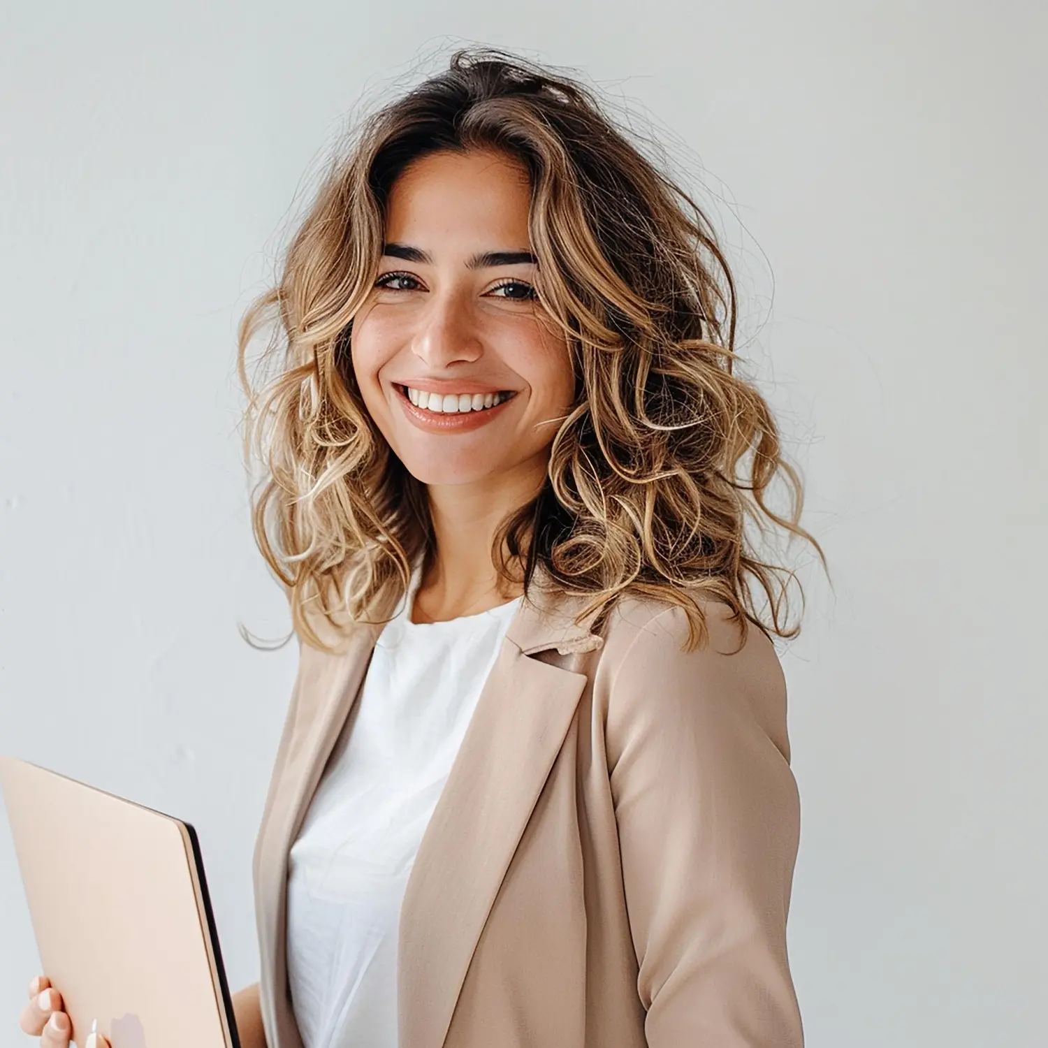 Smiling businesswoman holding a laptop, representing a professional Facebook Ads specialist.