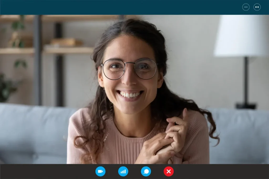 Smiling woman with glasses on a video call, representing online web design consultation services in a modern digital workspace.