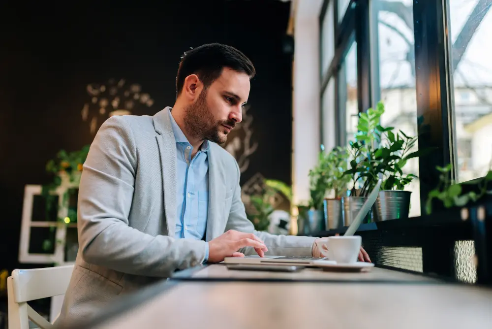 Profesional trabajando en portátil en oficina luminosa, ilustrando beneficios del CRM y la automatización para empresas.