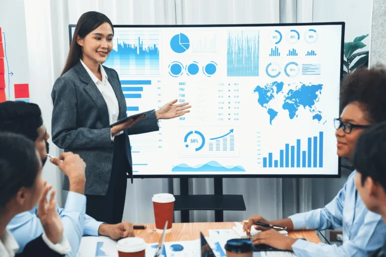 Agencia de marketing digital para empresas presentando resultados de campañas en reunión con gráficos y mapas.