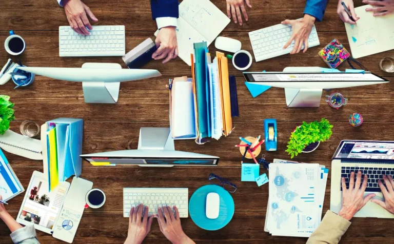 Equipo de agencia de publicidad en Nicaragua trabajando en computadoras y documentos en oficina