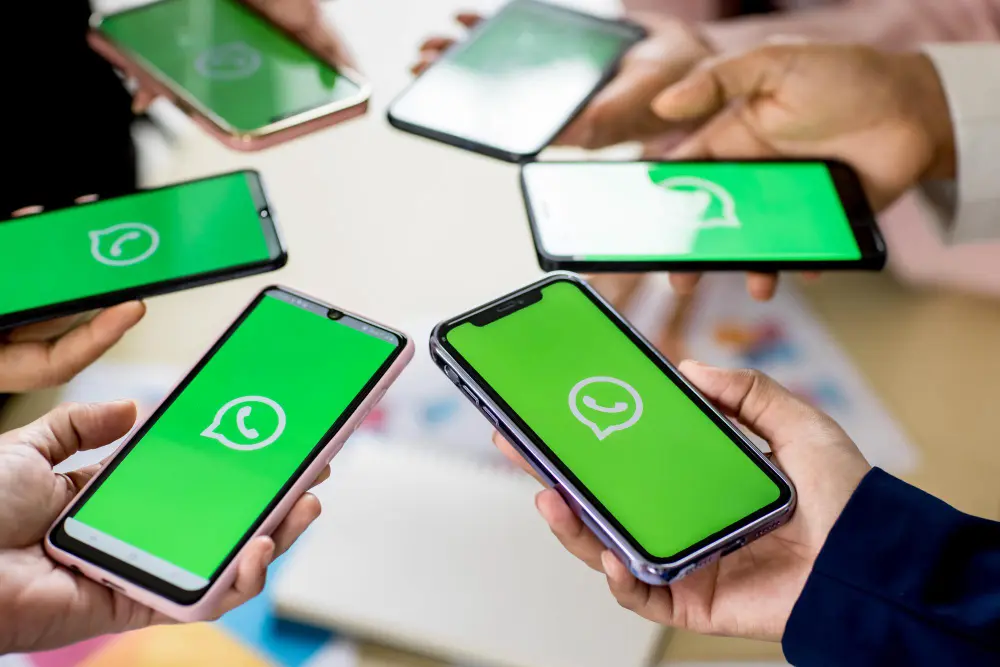 Varias personas sosteniendo teléfonos con WhatsApp abierto, CRM para WhatsApp para equipos comerciales.